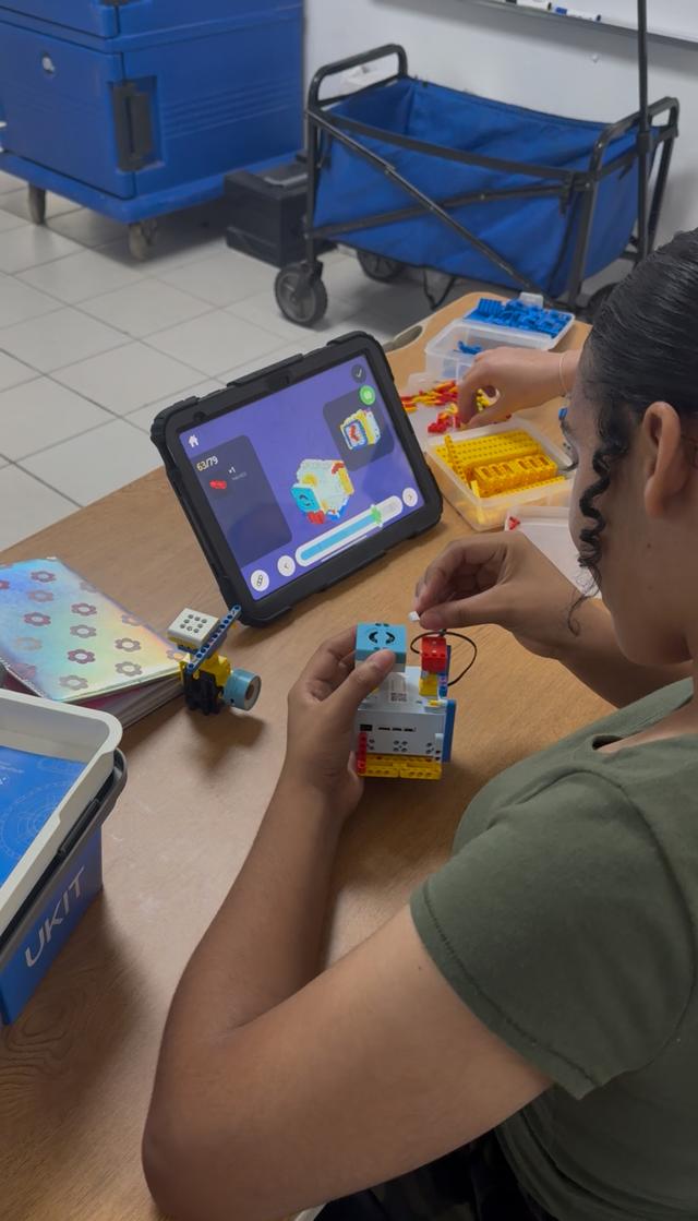 Estudiantes construyendo robots en equipo
